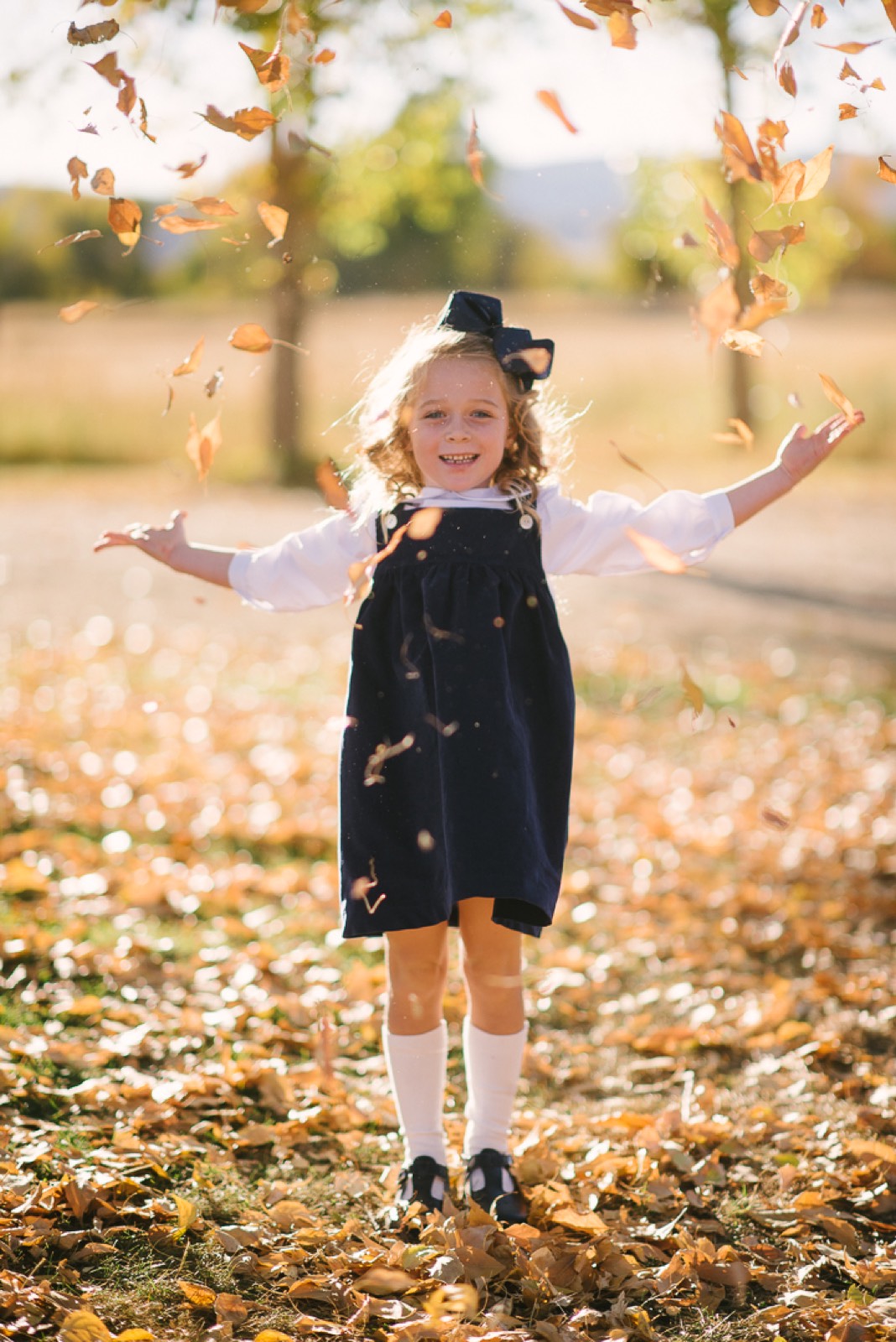 Young girl playing in fall leaves during Steamboat Springs family session