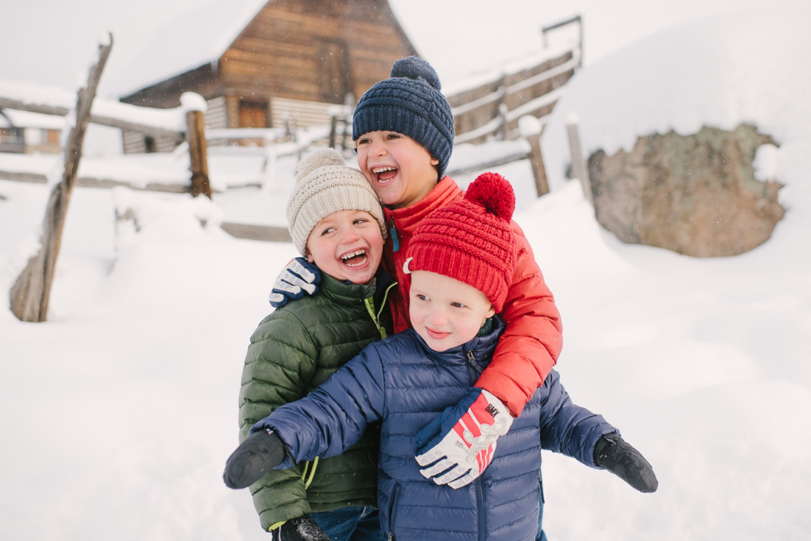 Kids laughing in the snow during a winter family session in Steamboat Springs